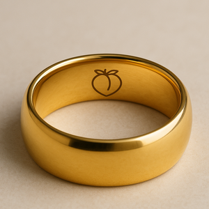 Gold ring with a peach emoji on a beige background